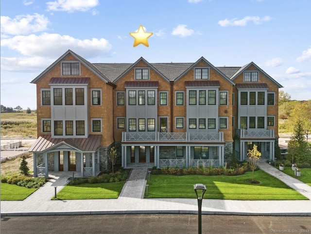 view of front facade with a balcony and a front lawn