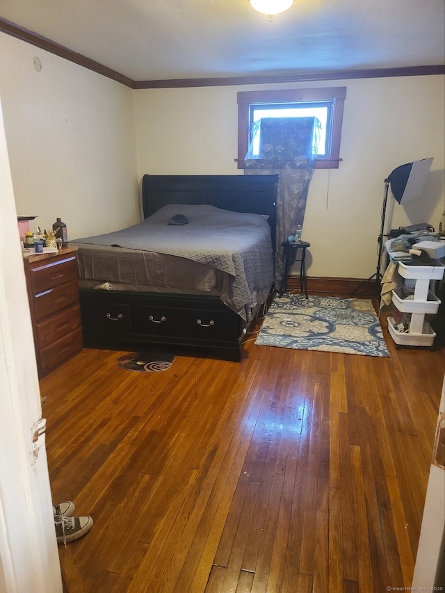 bedroom with wood-type flooring and crown molding