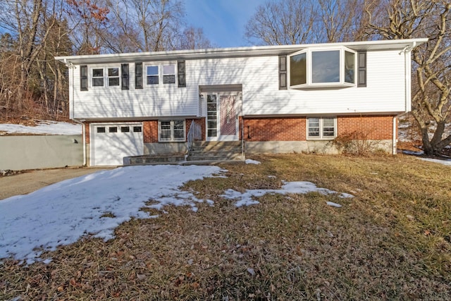 bi-level home with an attached garage and brick siding