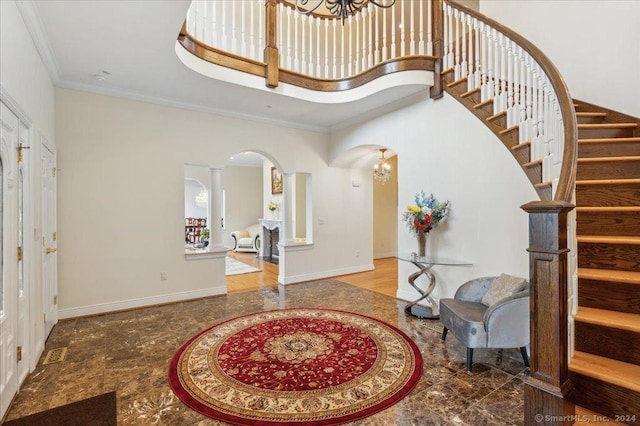 foyer entrance with a high ceiling and crown molding