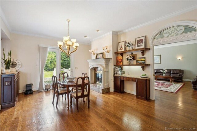 dining room featuring ornamental molding, a notable chandelier, and dark hardwood / wood-style flooring