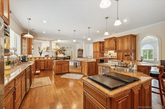 kitchen featuring decorative light fixtures, kitchen peninsula, sink, and a kitchen island