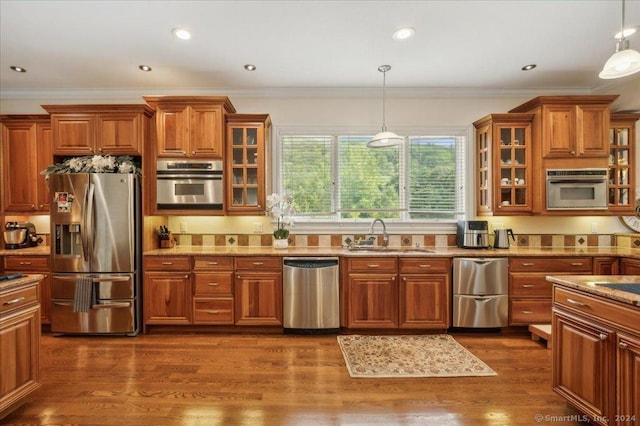 kitchen with stainless steel appliances, hanging light fixtures, sink, and dark hardwood / wood-style flooring