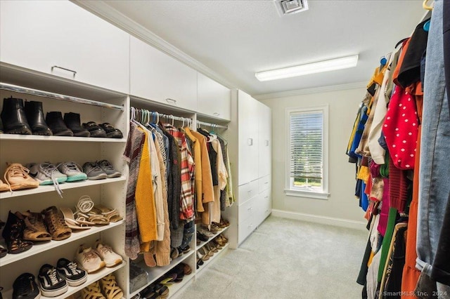 walk in closet featuring light carpet