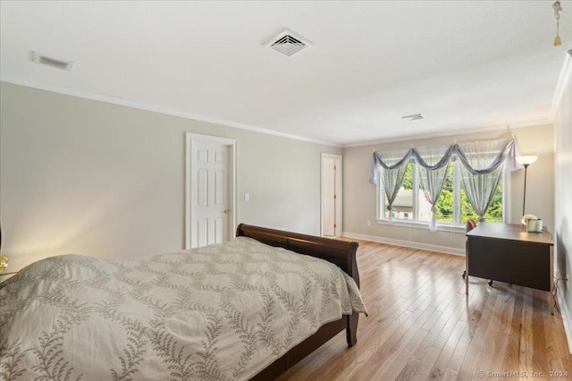 bedroom featuring crown molding and light hardwood / wood-style floors