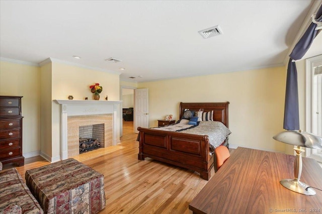 bedroom with ornamental molding and light hardwood / wood-style floors