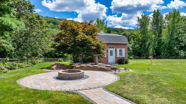 view of yard with an outbuilding, an outdoor fire pit, and a patio area