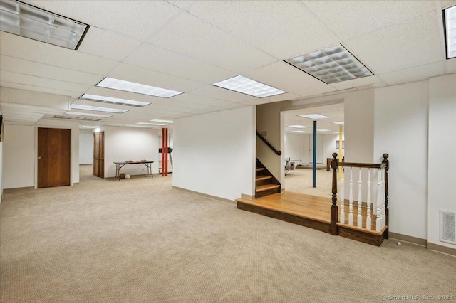 basement with carpet flooring and a paneled ceiling