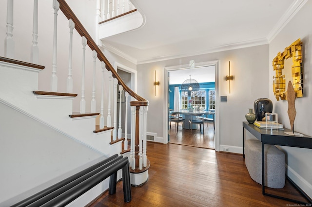 foyer entrance featuring ornamental molding, dark wood-type flooring, and baseboards