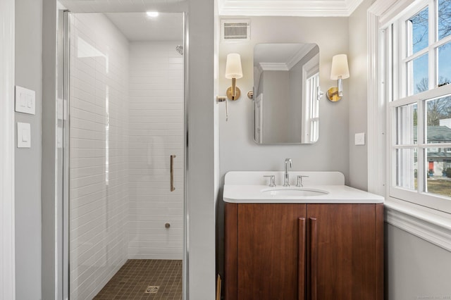 bathroom featuring visible vents, crown molding, a shower stall, and vanity