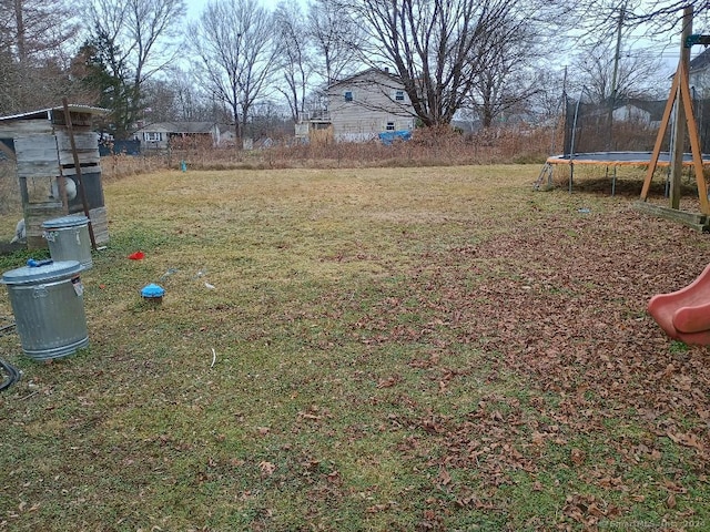 view of yard with a trampoline and a playground