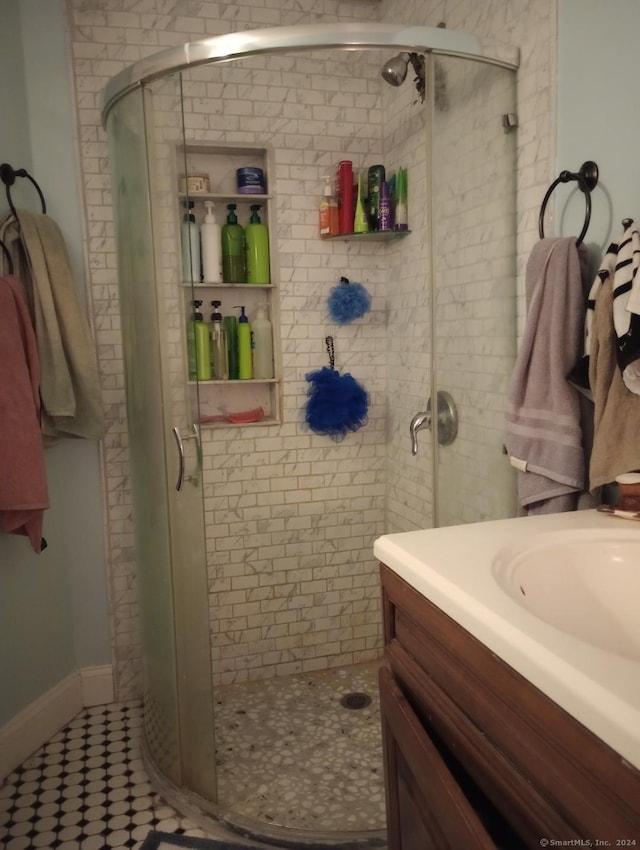 bathroom with vanity, an enclosed shower, and tile patterned flooring