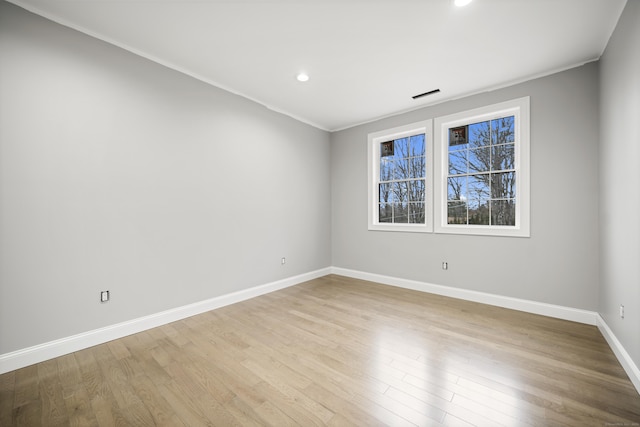 spare room featuring light hardwood / wood-style flooring and ornamental molding