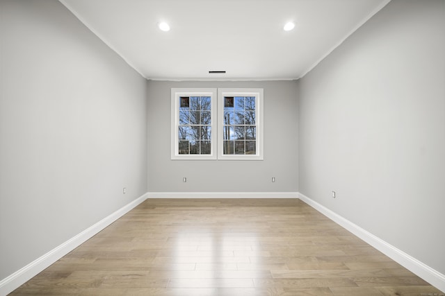 empty room featuring light hardwood / wood-style floors and ornamental molding