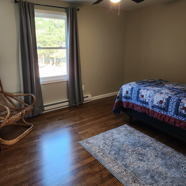 bedroom featuring multiple windows, dark hardwood / wood-style flooring, ceiling fan, and a baseboard heating unit