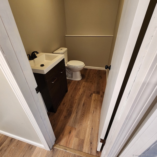 bathroom with vanity, wood-type flooring, and toilet