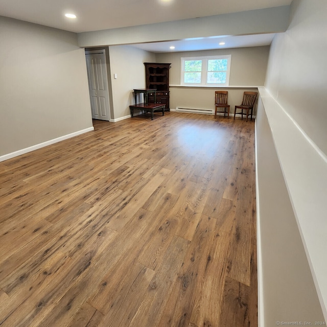 basement featuring hardwood / wood-style flooring and baseboard heating