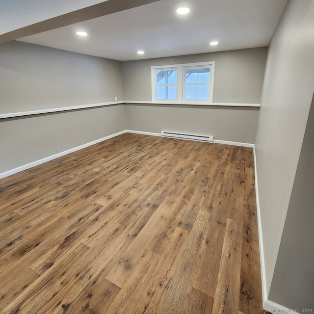 spare room with a baseboard radiator and hardwood / wood-style flooring