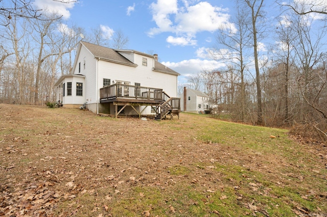 rear view of house featuring a lawn and a wooden deck