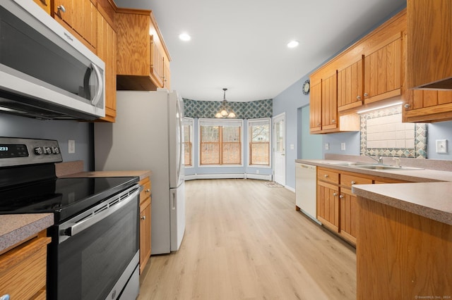 kitchen featuring sink, pendant lighting, dishwasher, a chandelier, and stainless steel range with electric cooktop