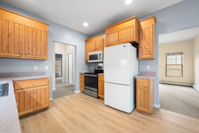 kitchen with white appliances and light hardwood / wood-style flooring