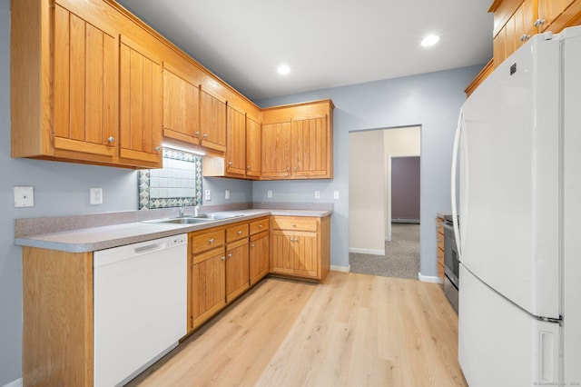 kitchen with sink, light hardwood / wood-style floors, and white appliances