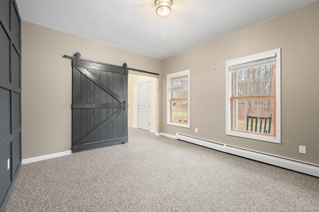 interior space with a barn door, carpet floors, and a baseboard heating unit