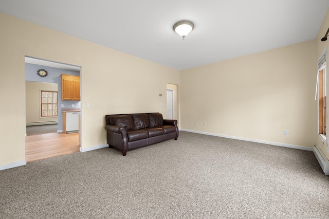 living area with light carpet and a baseboard heating unit