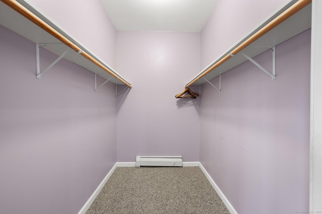 spacious closet with carpet floors and a baseboard radiator