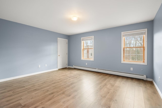 empty room with light wood-type flooring and baseboard heating