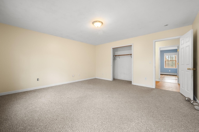 unfurnished bedroom with carpet flooring, a closet, and a baseboard radiator