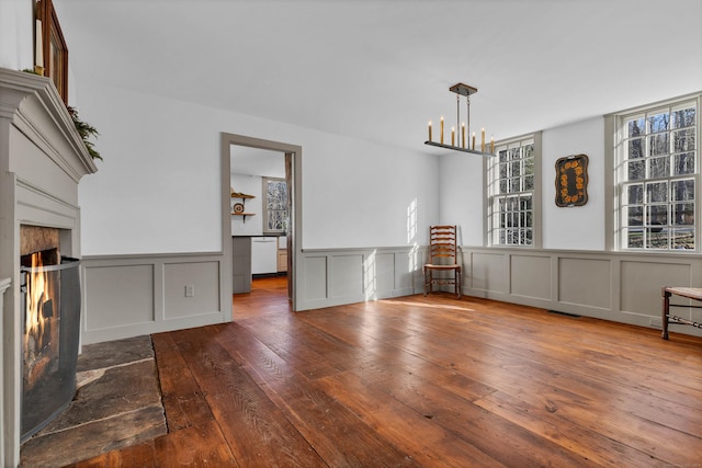 interior space with a premium fireplace, dark wood-type flooring, and an inviting chandelier