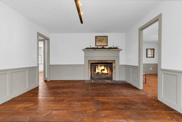 unfurnished living room with a premium fireplace and dark wood-type flooring