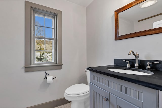 bathroom with tile patterned flooring, vanity, and toilet