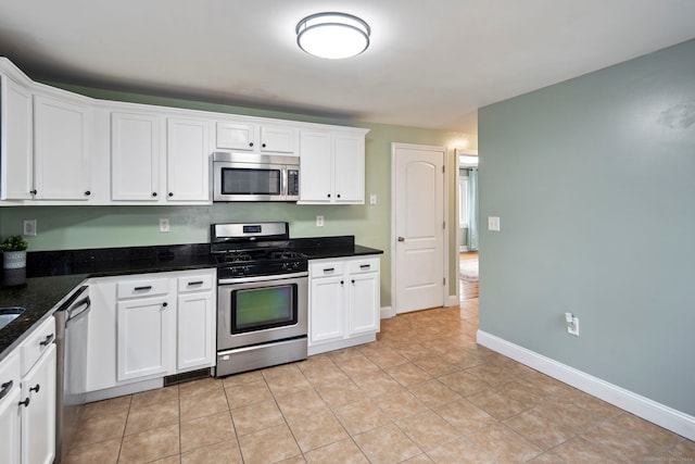 kitchen with dark stone countertops, white cabinetry, and appliances with stainless steel finishes