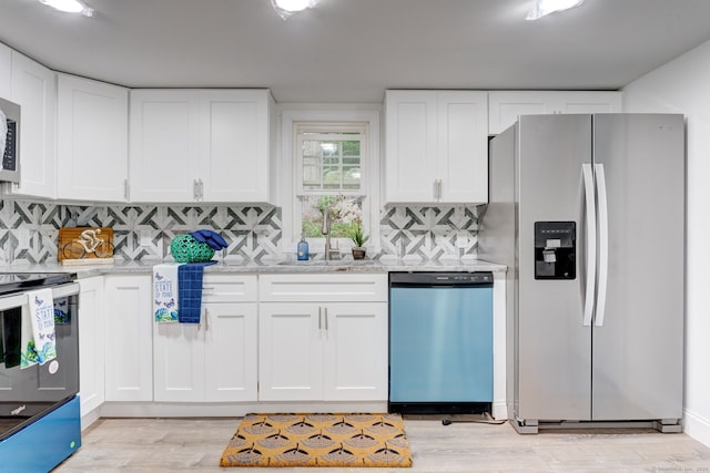 kitchen featuring white cabinetry, sink, stainless steel appliances, and light wood-type flooring