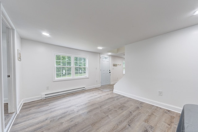 unfurnished room featuring light hardwood / wood-style flooring and a baseboard heating unit