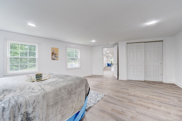 bedroom with light wood-type flooring and a closet