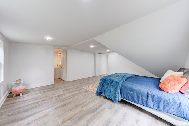 bedroom with light hardwood / wood-style floors and ensuite bath