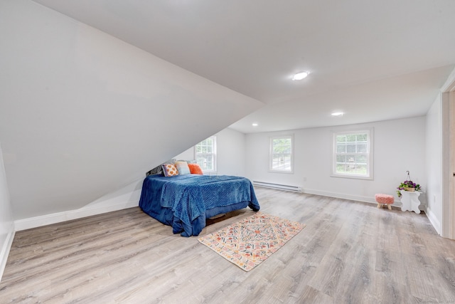 bedroom featuring light hardwood / wood-style floors and a baseboard heating unit