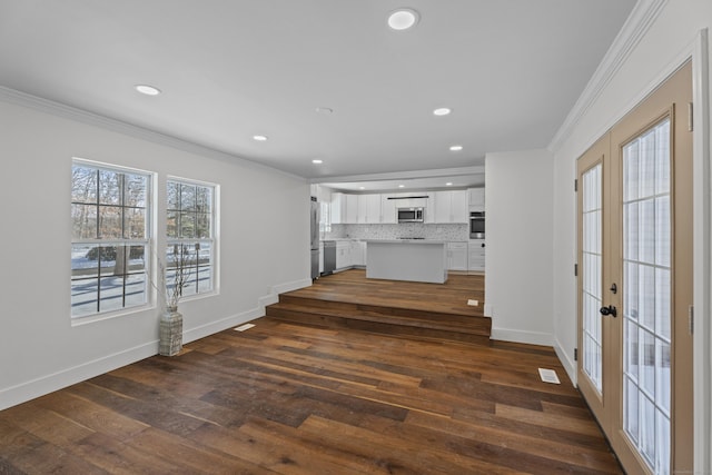 unfurnished living room featuring dark wood-type flooring, ornamental molding, and french doors