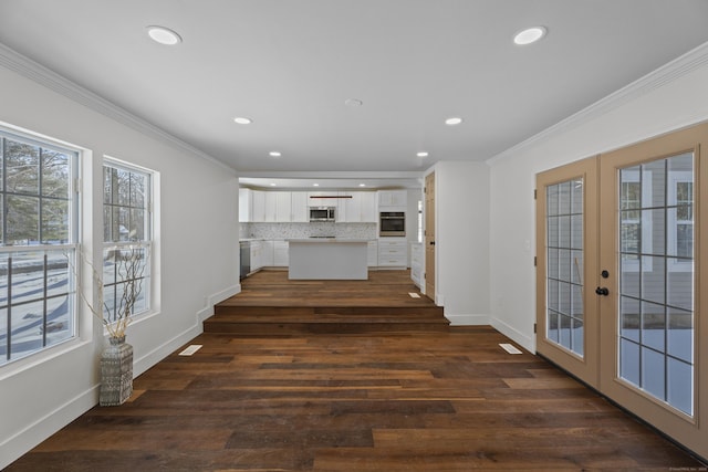 unfurnished living room featuring crown molding, dark hardwood / wood-style flooring, and french doors