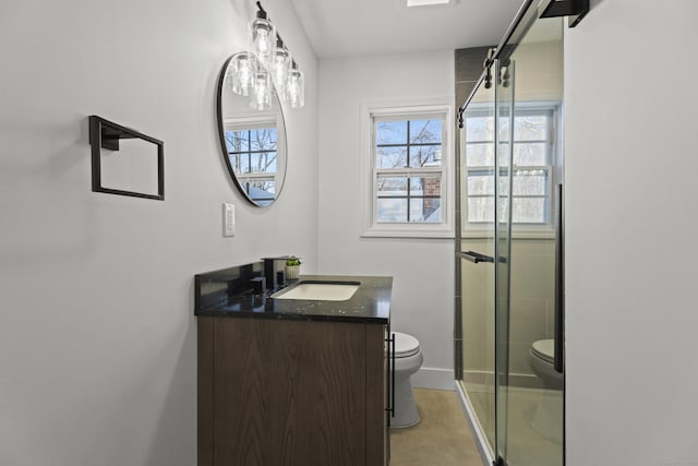 bathroom featuring vanity, a shower with shower door, and toilet