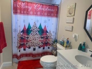 bathroom with a shower with curtain, vanity, and toilet