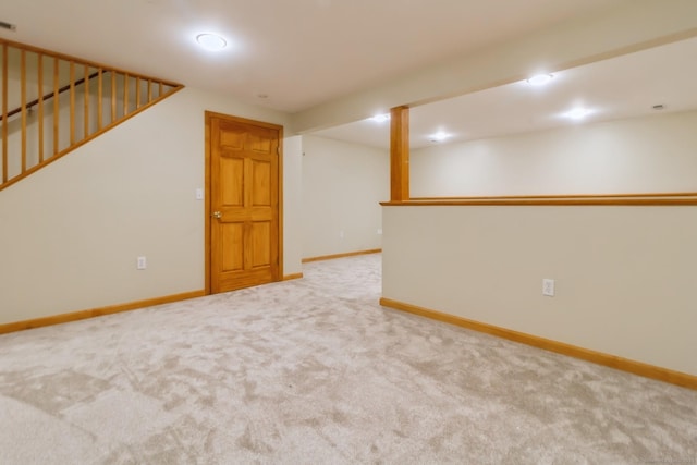 finished basement featuring carpet, baseboards, and stairway