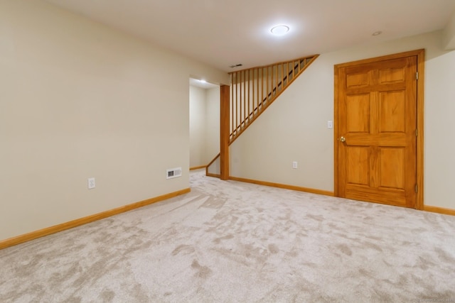 finished basement with baseboards, stairway, and carpet
