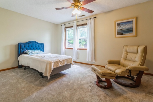 bedroom featuring carpet floors, baseboards, a textured ceiling, and ceiling fan