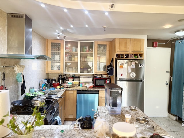 kitchen with decorative backsplash, appliances with stainless steel finishes, light stone counters, and wall chimney range hood