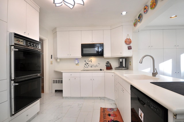 kitchen featuring radiator heating unit, sink, white cabinetry, and black appliances