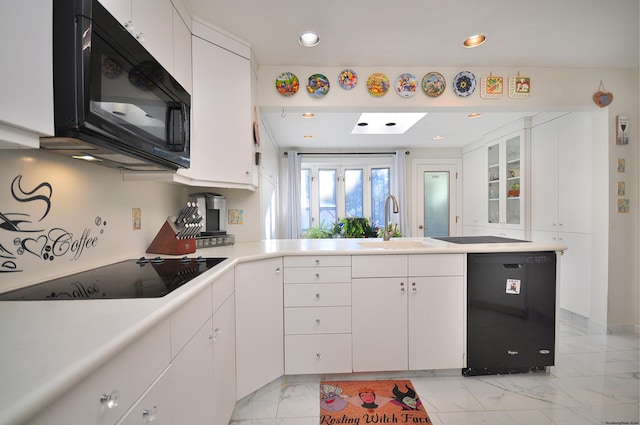 kitchen featuring sink, white cabinetry, and black appliances